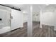 Renovated basement with wood-look flooring, modern sliding barn door, and support beams at 2537 Baker Nw Rd, Atlanta, GA 30318