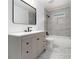 Modern bathroom with gray marble tiling, gray vanity, and black hardware fixtures at 2537 Baker Nw Rd, Atlanta, GA 30318