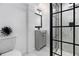 Modern bathroom featuring a glass-enclosed shower, gray vanity, and hexagon tile floors at 2537 Baker Nw Rd, Atlanta, GA 30318