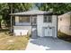 Charming renovated home with white brick, black trim, and an inviting front porch in a lush, wooded setting at 2537 Baker Nw Rd, Atlanta, GA 30318