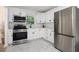 Well-equipped kitchen with stainless steel appliances, white cabinets, light countertops, and stylish hardware at 2537 Baker Nw Rd, Atlanta, GA 30318