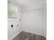 Bright laundry room with vinyl plank flooring, white walls, and hanging wire rack at 2537 Baker Nw Rd, Atlanta, GA 30318
