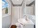 A clean and well-lit bathroom featuring a window for natural light, a shower with a curtain, and a stylish sink at 2545 Hickory Level Rd, Villa Rica, GA 30180