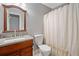 Bathroom features a wood vanity with granite countertop, white sink, toilet, and shower curtain at 2545 Hickory Level Rd, Villa Rica, GA 30180