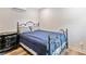 This bedroom features a wrought iron bed frame, light wood flooring, neutral walls, and a black dresser at 2545 Hickory Level Rd, Villa Rica, GA 30180