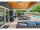 This covered outdoor patio features a ceiling fan, comfortable seating, television, outdoor kitchen, and access to the pool at 2545 Hickory Level Rd, Villa Rica, GA 30180
