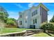 Back of house shows brick and white siding with green backyard and brick retaining wall at 3400 Dencrest Se Ct, Smyrna, GA 30080