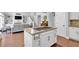Open-concept kitchen with island cooktop, seamlessly connecting to the living area and staircase at 3400 Dencrest Se Ct, Smyrna, GA 30080