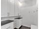Bright mudroom with white cabinets, black countertops, and a bench with hooks at 3400 Dencrest Se Ct, Smyrna, GA 30080
