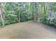 Level backyard area surrounded by mature trees, offering privacy and space for outdoor activities at 5345 Pilgrim Point Rd, Cumming, GA 30041