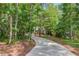 Scenic driveway winding through lush trees, leading to a secluded home at 5345 Pilgrim Point Rd, Cumming, GA 30041