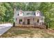 Charming cottage-style home with a welcoming front porch and well-manicured lawn at 5345 Pilgrim Point Rd, Cumming, GA 30041