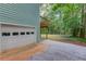 Exterior showing a garage with access to a deck and a lush backyard at 5345 Pilgrim Point Rd, Cumming, GA 30041