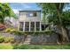 Back exterior view featuring screened porch, stone retaining wall, and landscaped yard at 1748 N Pelham Ne Rd, Atlanta, GA 30324