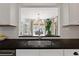 Bright kitchen with stainless steel sink, black countertops, and a window overlooking the dining area at 1748 N Pelham Ne Rd, Atlanta, GA 30324