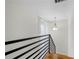 Stairway hall with modern railing, hardwood floors, and a stylish hanging light fixture at 1924 Variations Ne Dr, Atlanta, GA 30329