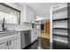 Open concept kitchen with stainless steel dishwasher, white cabinets, and black tile flooring at 1924 Variations Ne Dr, Atlanta, GA 30329
