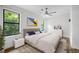 Staged primary bedroom features an upholstered bed, modern decor, and windows with natural light at 1924 Variations Ne Dr, Atlanta, GA 30329