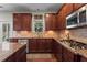 Modern kitchen featuring granite countertops, stainless steel appliances, and dark wood cabinets at 237 Parc Drive Dr, Canton, GA 30114
