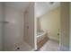 Bright bathroom featuring a walk-in shower and a soaking tub with tile surround at 1276 Lanier Ne Blvd, Atlanta, GA 30306
