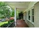 Inviting front porch with brick flooring, white columns, and lush garden views at 1276 Lanier Ne Blvd, Atlanta, GA 30306