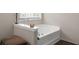 Bright bathroom features a bathtub, window, and hardwood floor at 140 Melrose Creek Dr, Stockbridge, GA 30281