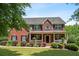 Traditional brick home with a covered front porch and manicured landscaping at 140 Melrose Creek Dr, Stockbridge, GA 30281