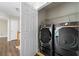 Modern laundry room featuring high-end, black stainless steel washer and dryer at 140 Melrose Creek Dr, Stockbridge, GA 30281