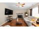Inviting living room featuring a fireplace, ceiling fan, and hardwood flooring at 140 Melrose Creek Dr, Stockbridge, GA 30281