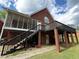 Backyard with screened porch, deck, black stairs, and brick pillar supports at 349 Bald Rock Rd, Oxford, GA 30054