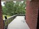 A backyard deck with black metal railing, wood floors, and view of trees at 349 Bald Rock Rd, Oxford, GA 30054