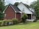 Well-maintained brick home with a charming porch, complemented by lush greenery and mature trees at 349 Bald Rock Rd, Oxford, GA 30054