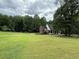 Spacious front yard with a beautiful brick home nestled among mature trees at 349 Bald Rock Rd, Oxford, GA 30054