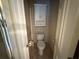 A small toilet room with striped wallpaper and a built-in cabinet above the toilet at 349 Bald Rock Rd, Oxford, GA 30054