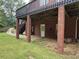 Backyard view featuring under-deck space with brick supports and staircase at 349 Bald Rock Rd, Oxford, GA 30054