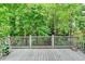 Private deck with wooden railing surrounded by lush greenery offers a serene outdoor space at 1595 Chadberry Way, Lawrenceville, GA 30043
