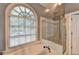 Relaxing bathroom with a large window over tub and glass enclosed shower at 1595 Chadberry Way, Lawrenceville, GA 30043