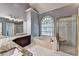 Bathroom features a granite countertop vanity, garden tub, and glass shower at 1595 Chadberry Way, Lawrenceville, GA 30043
