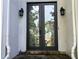 Elegant glass and iron front door with sidelights flanked by wall sconces at 1595 Chadberry Way, Lawrenceville, GA 30043