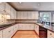 Bright kitchen showcasing wooden floors, white cabinets and black dishwasher at 1595 Chadberry Way, Lawrenceville, GA 30043