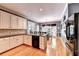 Eat in kitchen featuring white cabinets, wood floors, black dishwasher, and plenty of sunlight at 1595 Chadberry Way, Lawrenceville, GA 30043