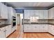 Spacious kitchen featuring wood floors, white cabinets and modern stainless appliances at 1595 Chadberry Way, Lawrenceville, GA 30043