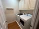 Convenient laundry room with wood floors, washer, dryer, and upper cabinets at 1595 Chadberry Way, Lawrenceville, GA 30043