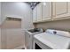 Practical laundry room with modern washer and dryer units with overhead cabinets at 1595 Chadberry Way, Lawrenceville, GA 30043
