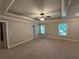 Large bedroom with carpet, ceiling fan, and tray ceilings at 1595 Chadberry Way, Lawrenceville, GA 30043