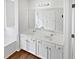 Bathroom featuring double sinks with white cabinets and a large mirror at 3968 Oak Glenn Dr, Duluth, GA 30096