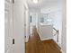 Hallway featuring hardwood floors, white walls, and a modern light fixture at 3968 Oak Glenn Dr, Duluth, GA 30096