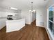 Bright, open-concept living and kitchen area with hardwood floors and white cabinets at 3968 Oak Glenn Dr, Duluth, GA 30096