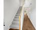 Carpeted staircase with wood handrail and hardwood flooring at 3968 Oak Glenn Dr, Duluth, GA 30096