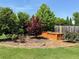Well-maintained backyard featuring a variety of plants and a wooden garden box at 724 Laura Jean Ct, Buford, GA 30518